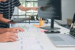 PCやタブレットを使用しながら話し合う人々