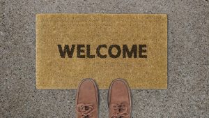 WELCOMEとプリントされた絨毯マットと一足の靴