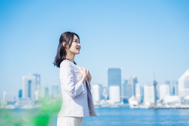 オフィスビルを背景に立つ女性