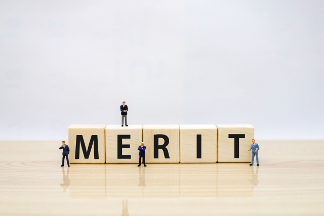 「MERIT」のブロックとビジネスマンのミニチュア