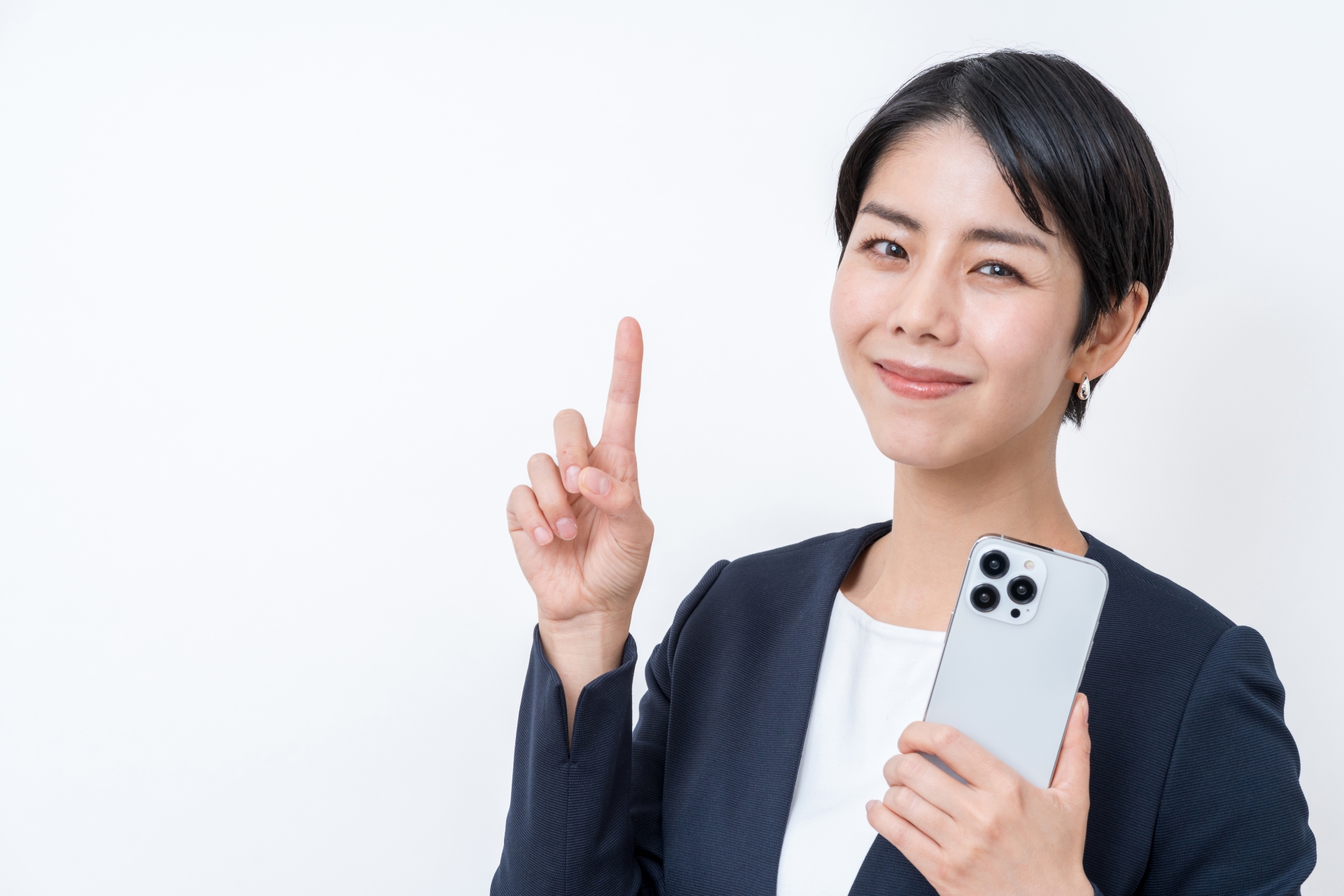 スマホ片手に人差し指を立てる女性