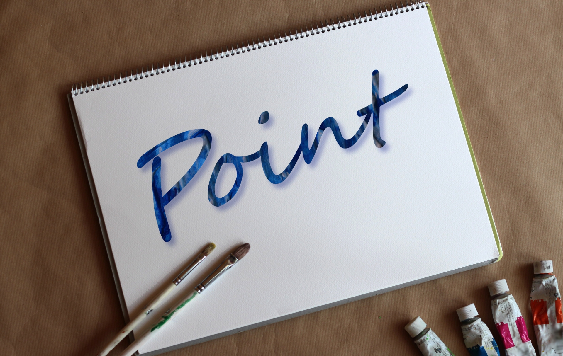 筆や絵の具と、「Point」と書かれたスケッチブック