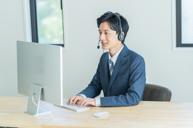 ヘッドセットをつけて対応する若手男性