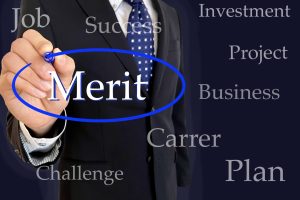 「Merit」にマーキングをするスーツ姿の男性
