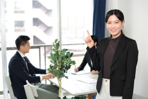 商談中のテーブルの前で指を立てる女性