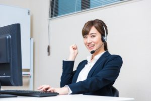 ヘッドセットでPCに向かう女性