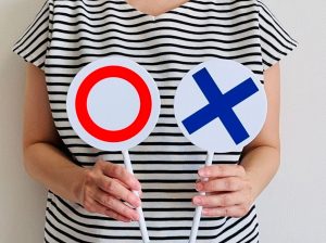 ○×の札を持つ女性