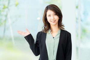 右手を上げて案内する女性ビジネスパーソン