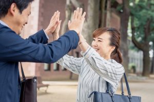 笑顔でハイタッチする男女営業パーソン