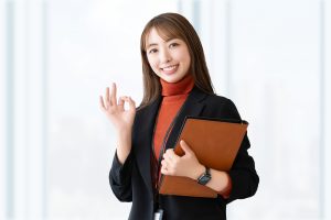 指でOKサインを作る女性ビジネスパーソン