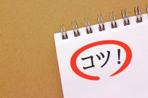 メモ帳に書かれた赤丸囲みのコツの文字