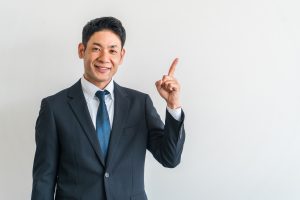 人差し指を立てるビジネスパーソン
